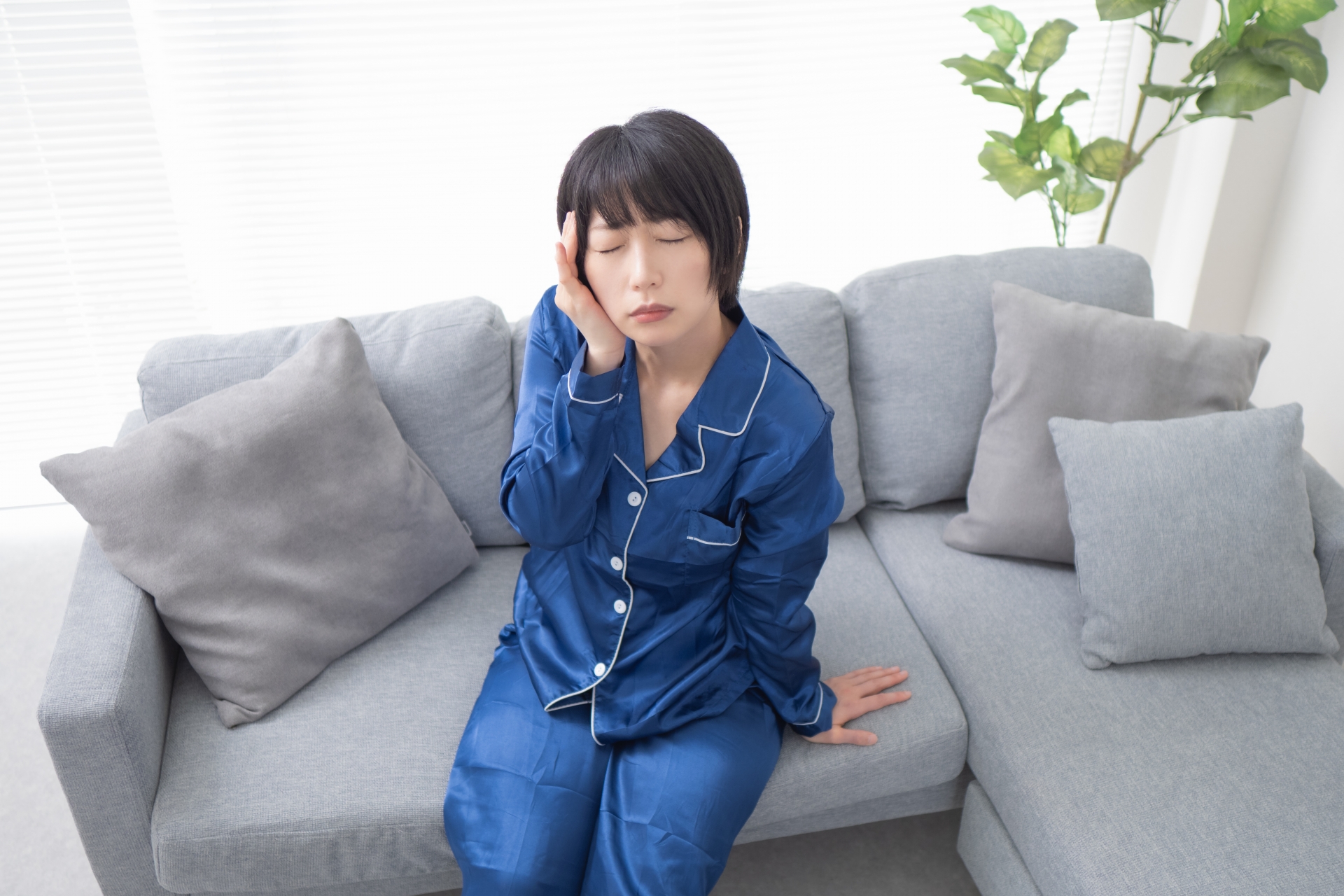 頭痛でこめかみをおさえる